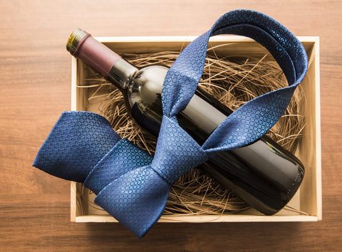 bottle of red wine with blue tie in box