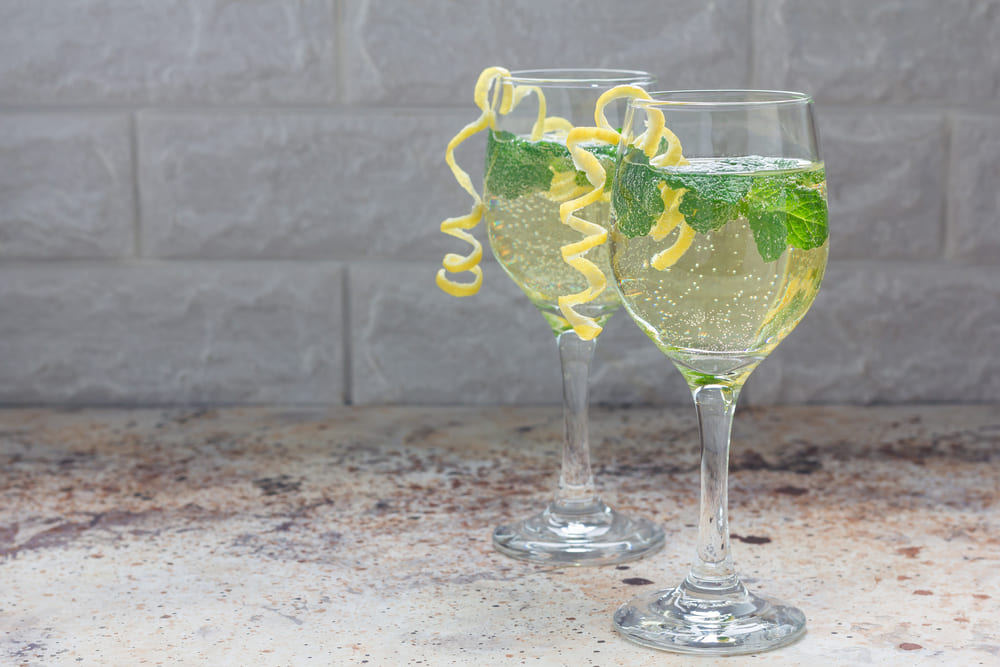 two white wine spritzers with lemon and mint